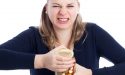 A young woman struggling to open a jar